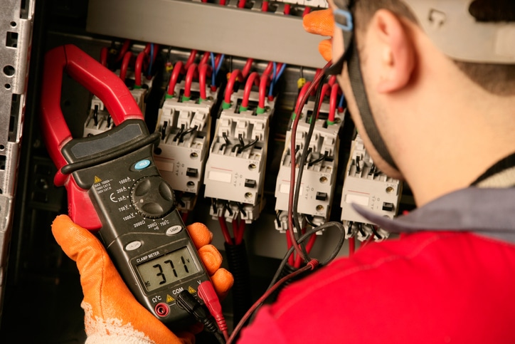 An electrician working on electric panel