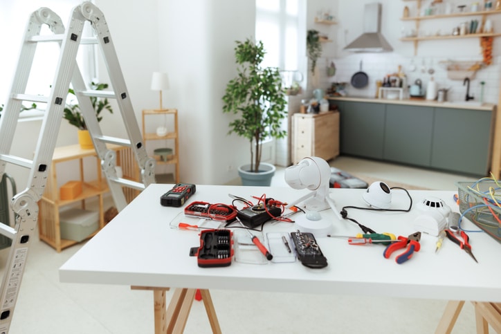 Smart home installation tools and surveillance equipment setup in modern kitchen space.