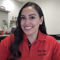 Felicia, Red Fox Electric Office Manager, Smiling In Branded Red Company Uniform At Denver Office.